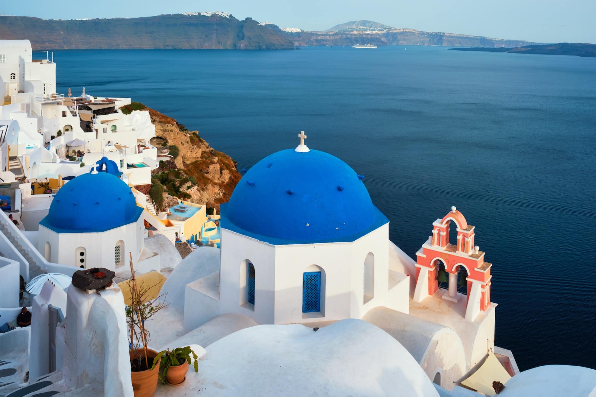 Famous view from viewpoint of Santorini Oia village with blue dome of greek orthodox Christian