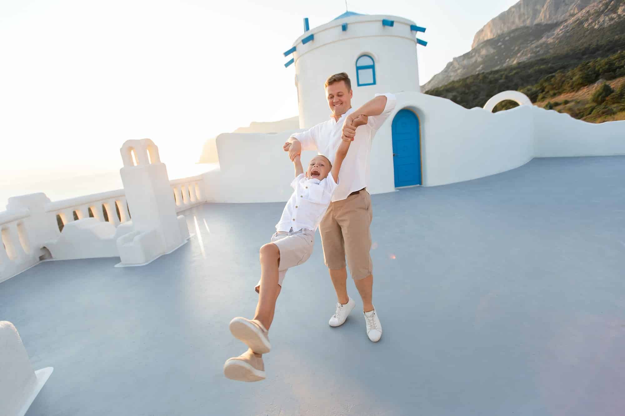 Father circles his son at sunset. on the island of Santorini, Greece.