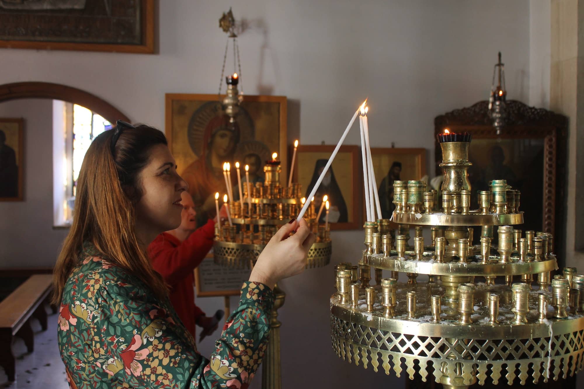 Woman burning candles in an orthodox church. Crete