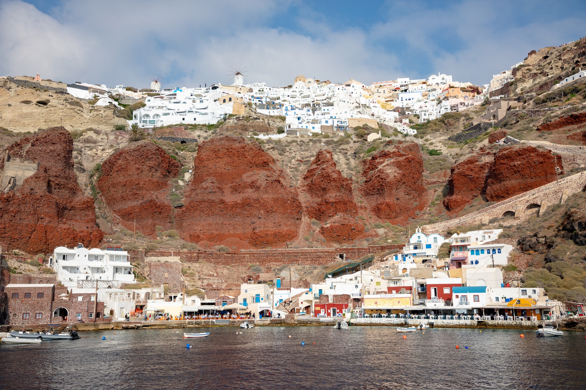 View of Oia village with white houses on red rocks caldera of Santorini Island in Greece
