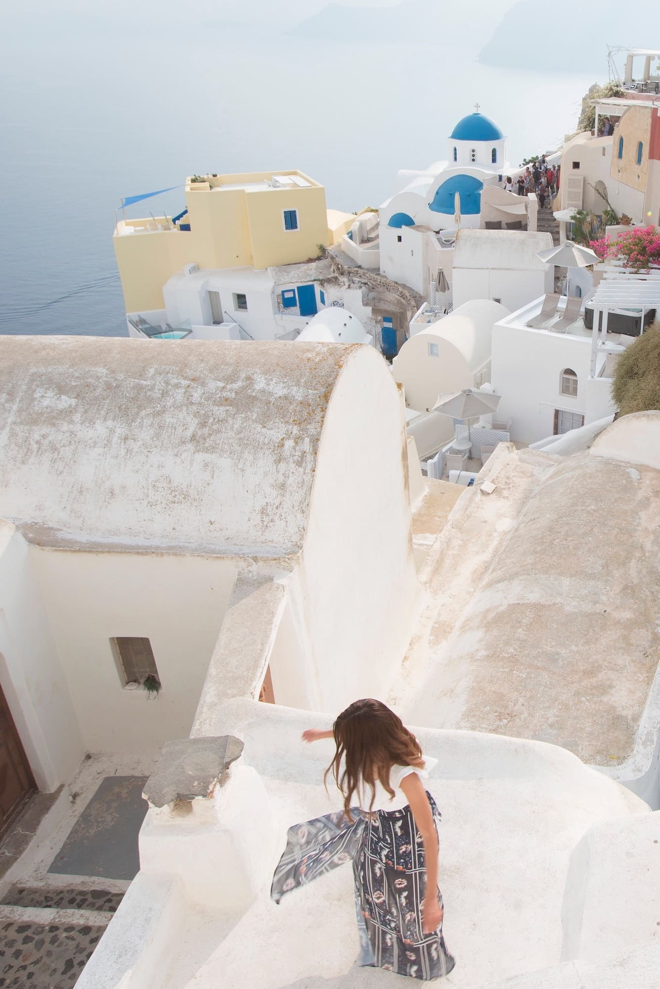 Young woman spinning in her dress and having fun in oia santorini