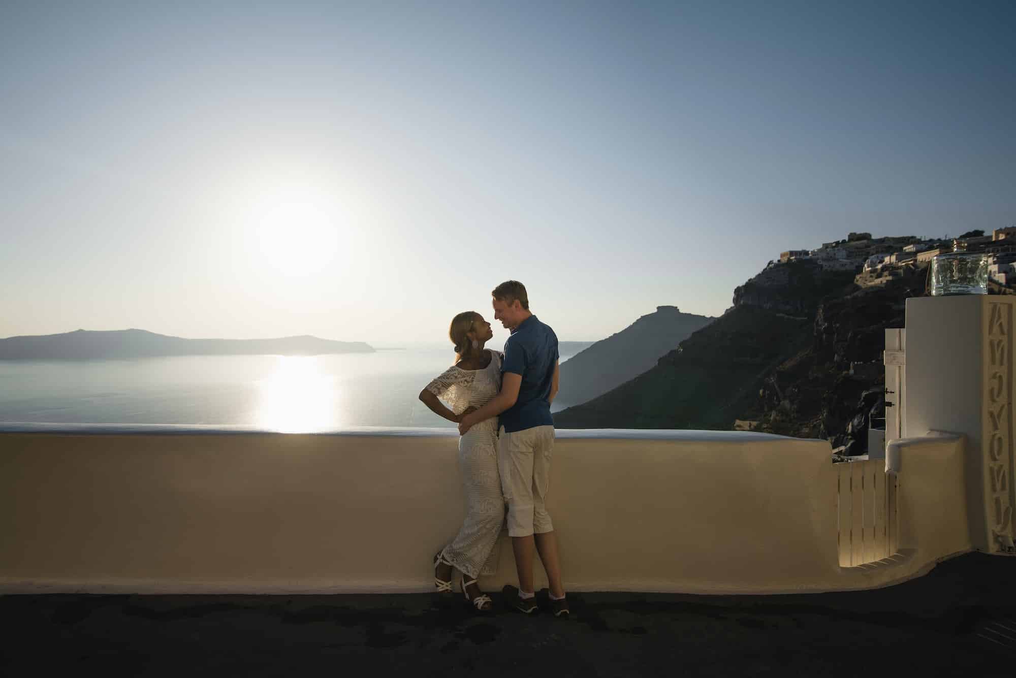 A loving couple walks the streets of the old city on the island of Santorini.