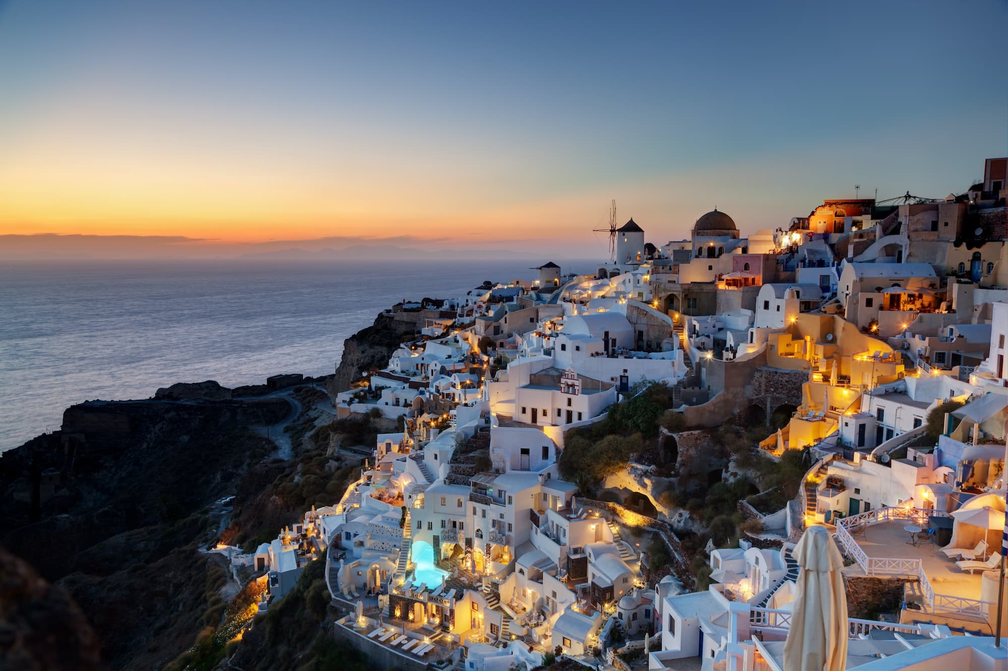 Oia town on Santorini island, Greece at sunset. Famous windmills