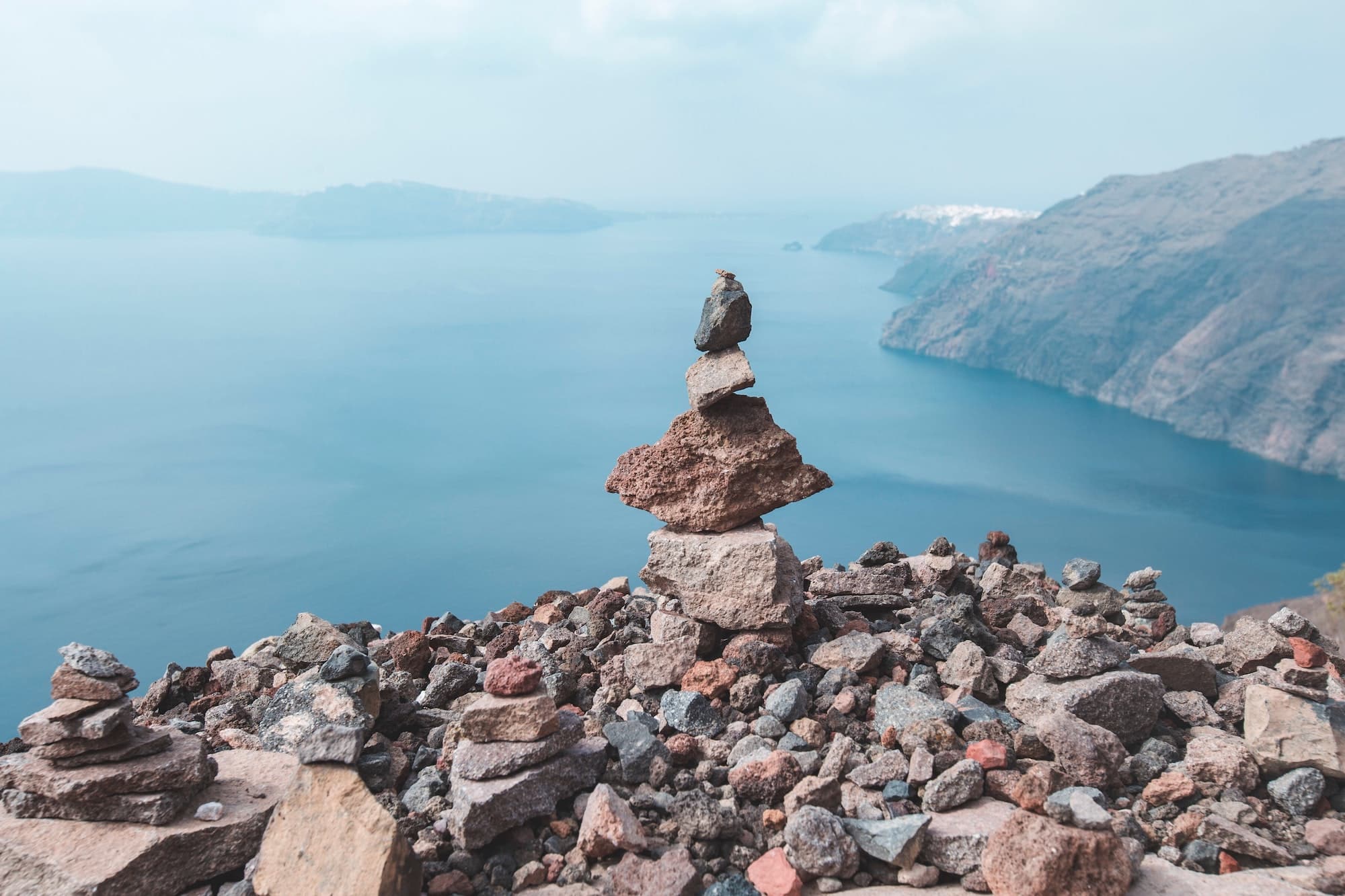 Stacked stones with an Aegean Sea ocean view in santorini Greece