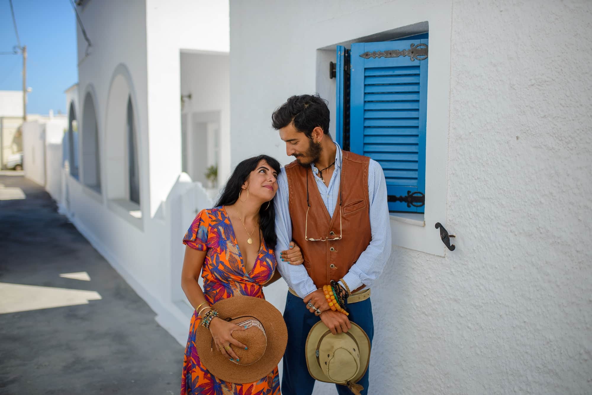 A man and a woman are posing in the streets of Imerovigli Village, on Santorini Island.