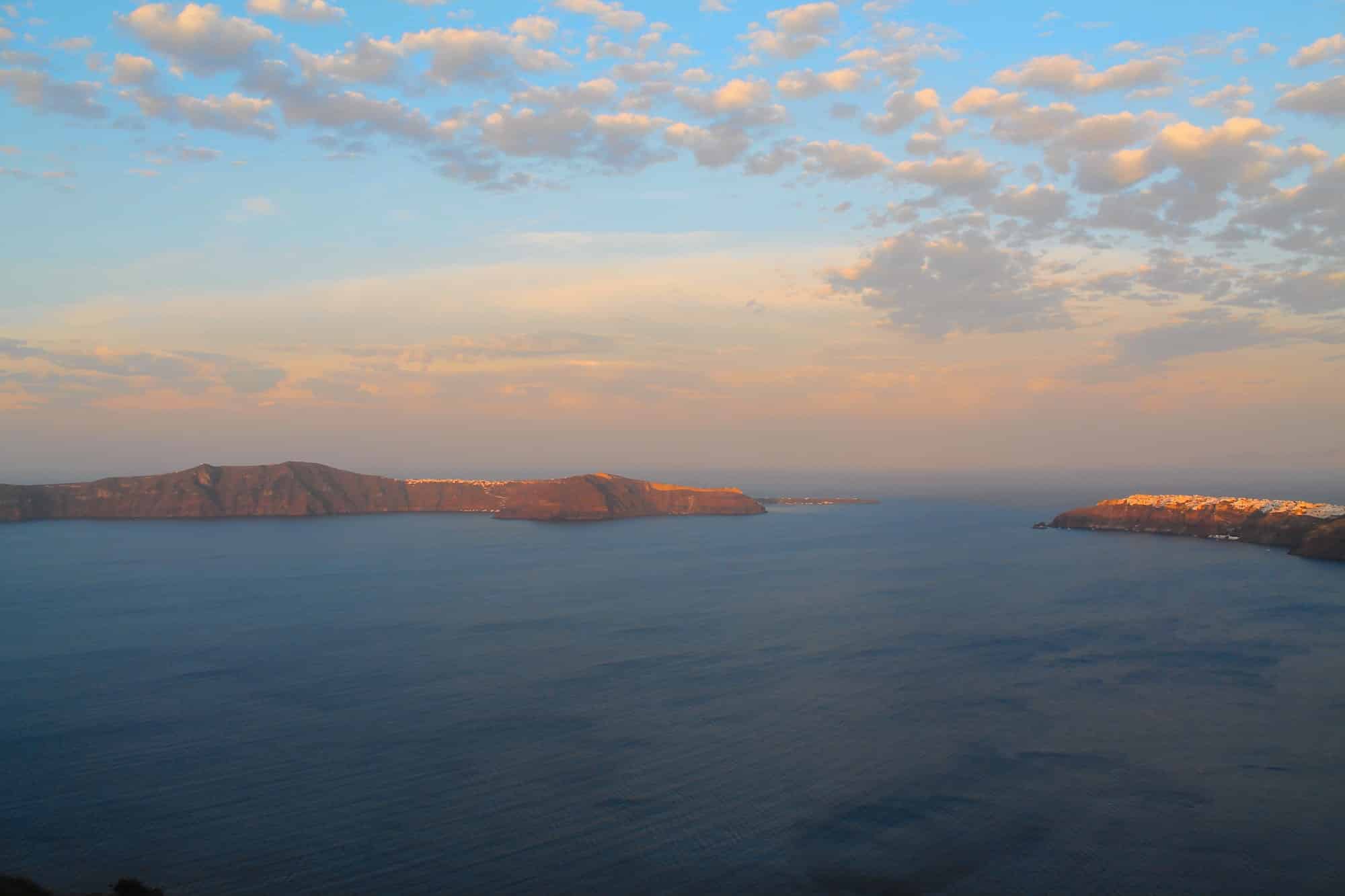 Sunrise, panoramic bird's-eye view of the blue sky and bright sea on the island of Santorini, Greece