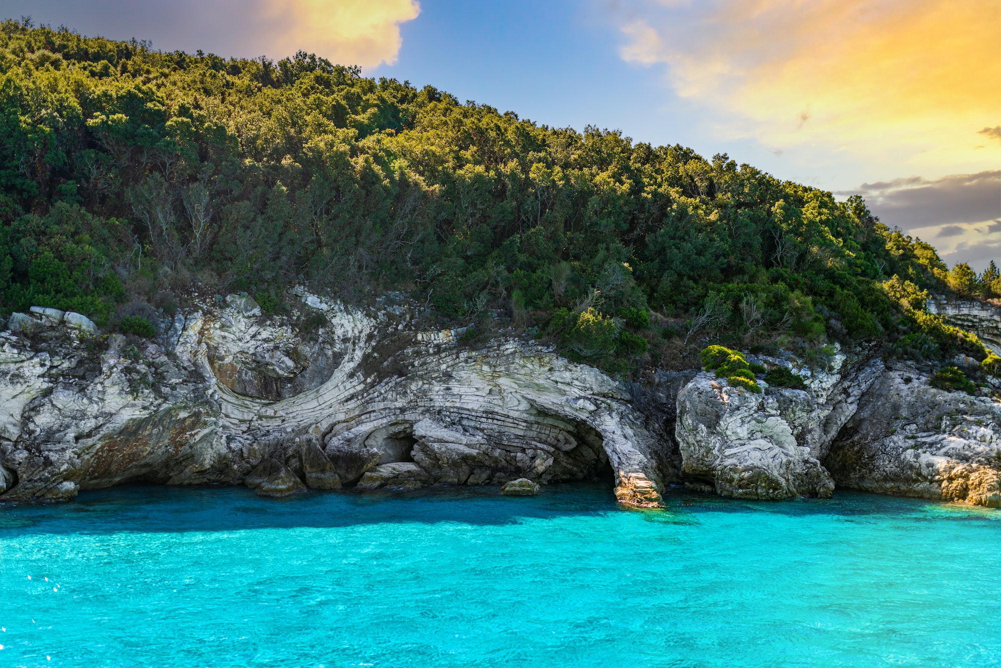 Layered rocks of mountain with forest on top on Corfu island