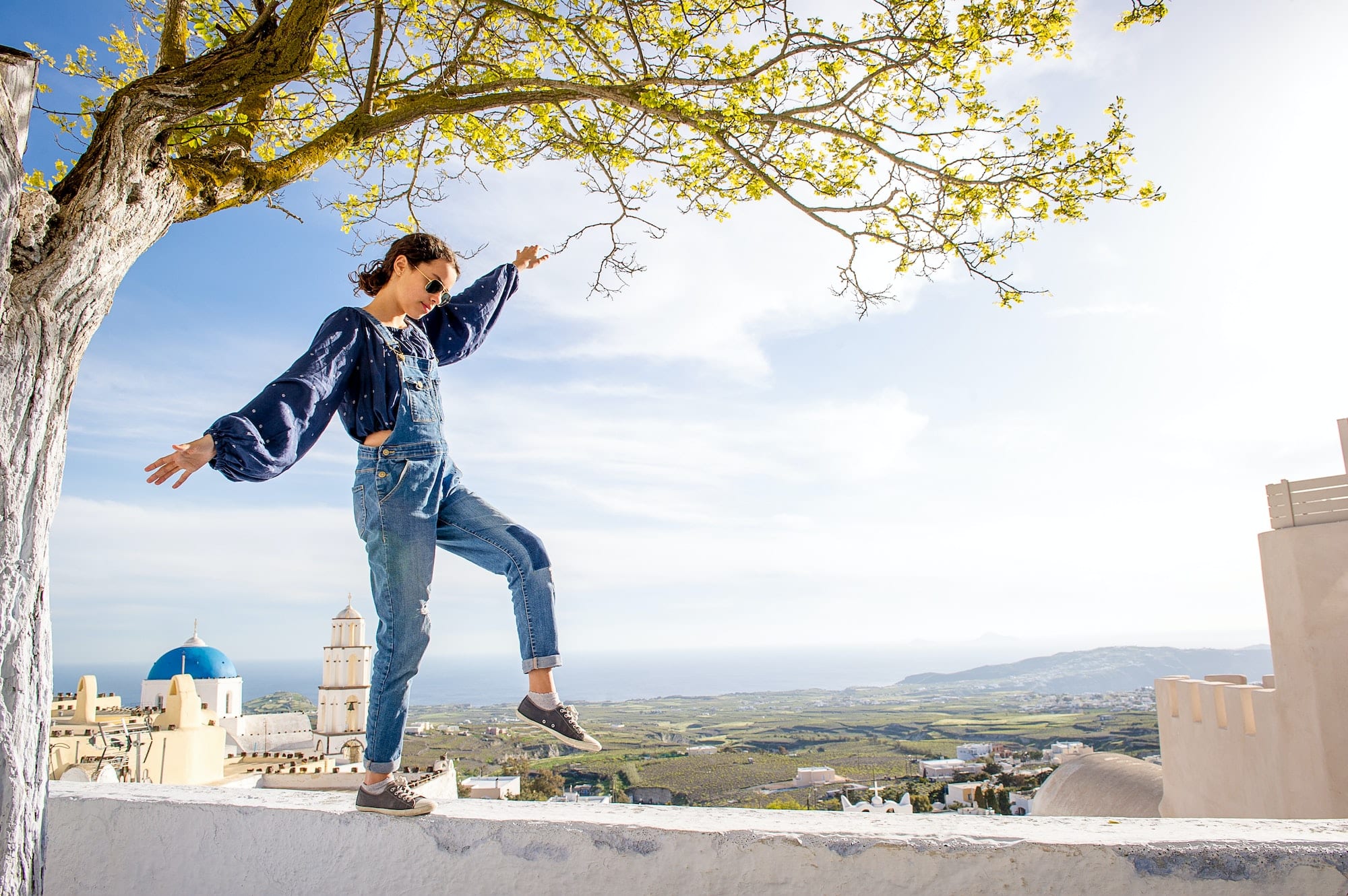 Girl balancing on top of wall, Oía, Santorini, Kikladhes, Greece