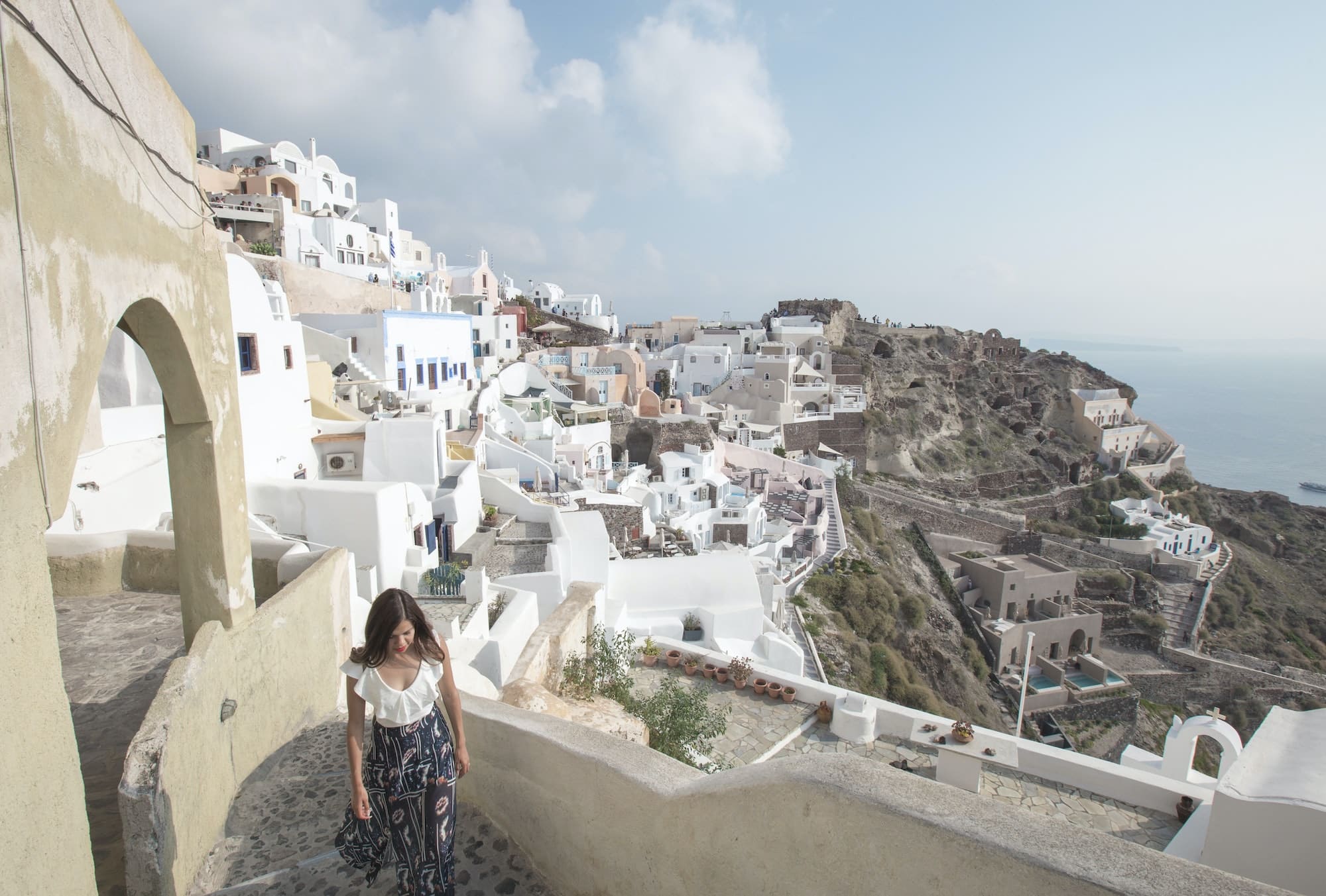 Young Woman in a dress walking the streets of the greek island of santorini