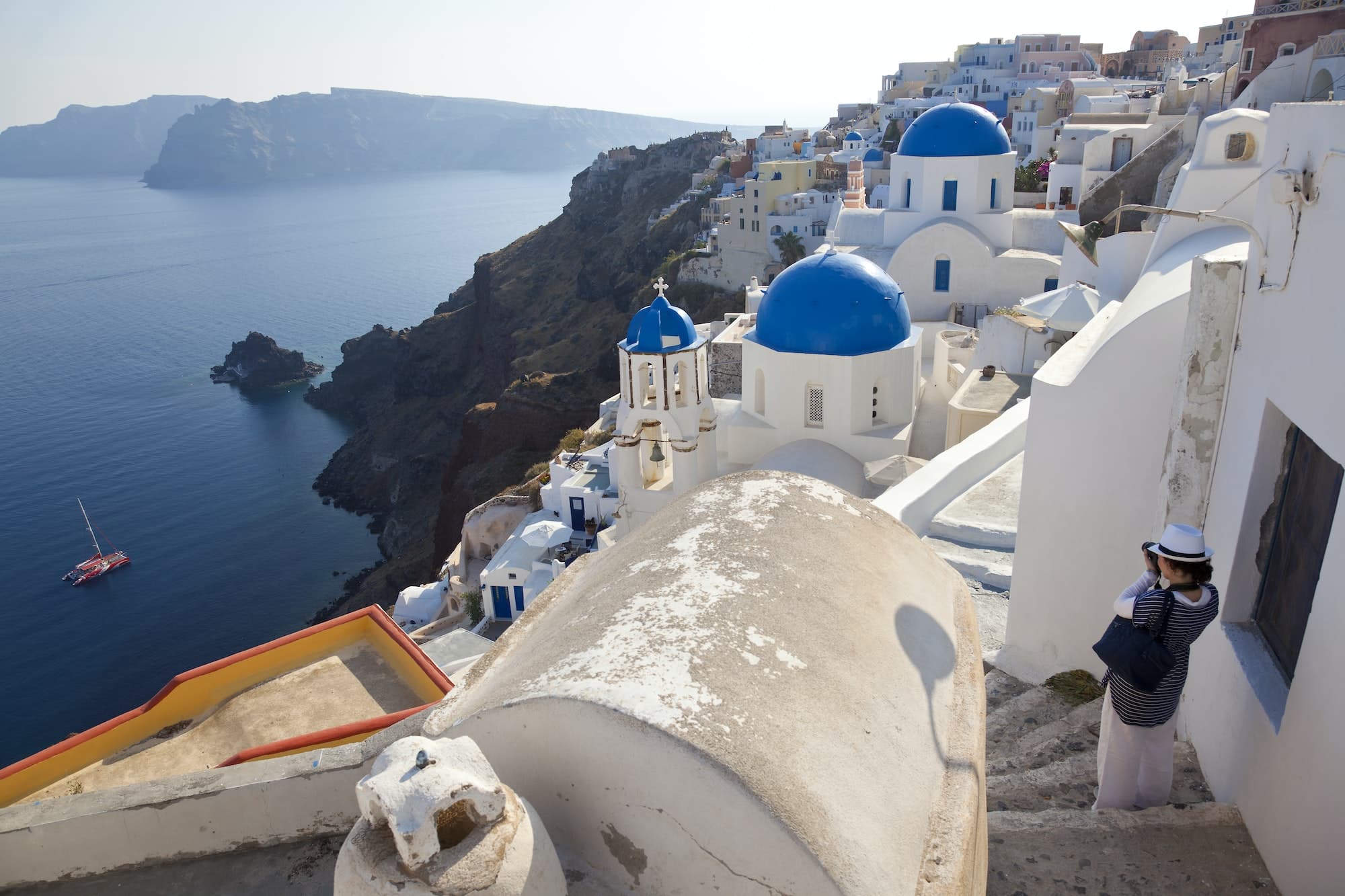 White washed church with bright blue dome on the island of Santorini