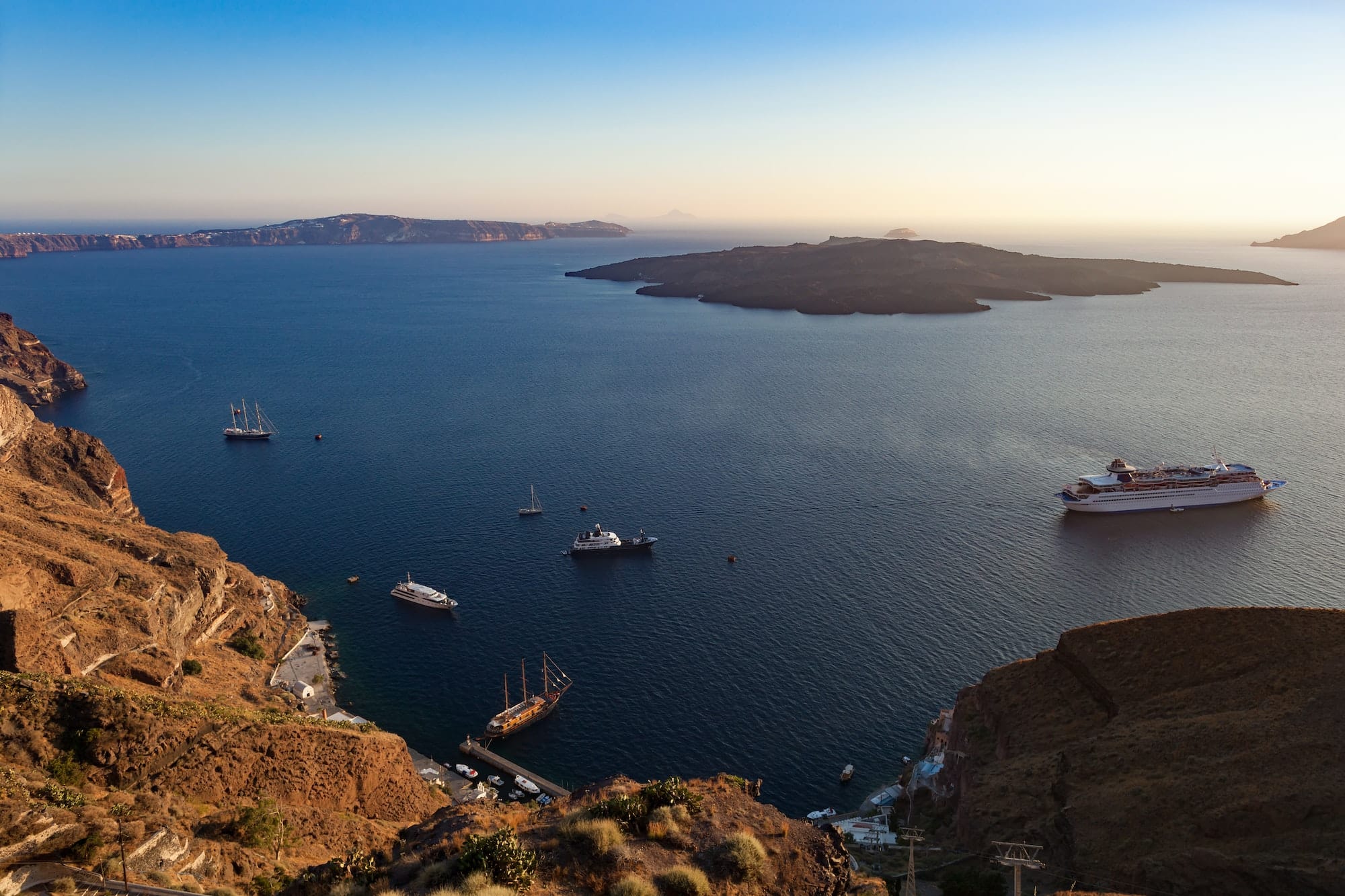 Oia caldera over Aegean sea at sunset, Santorini island.