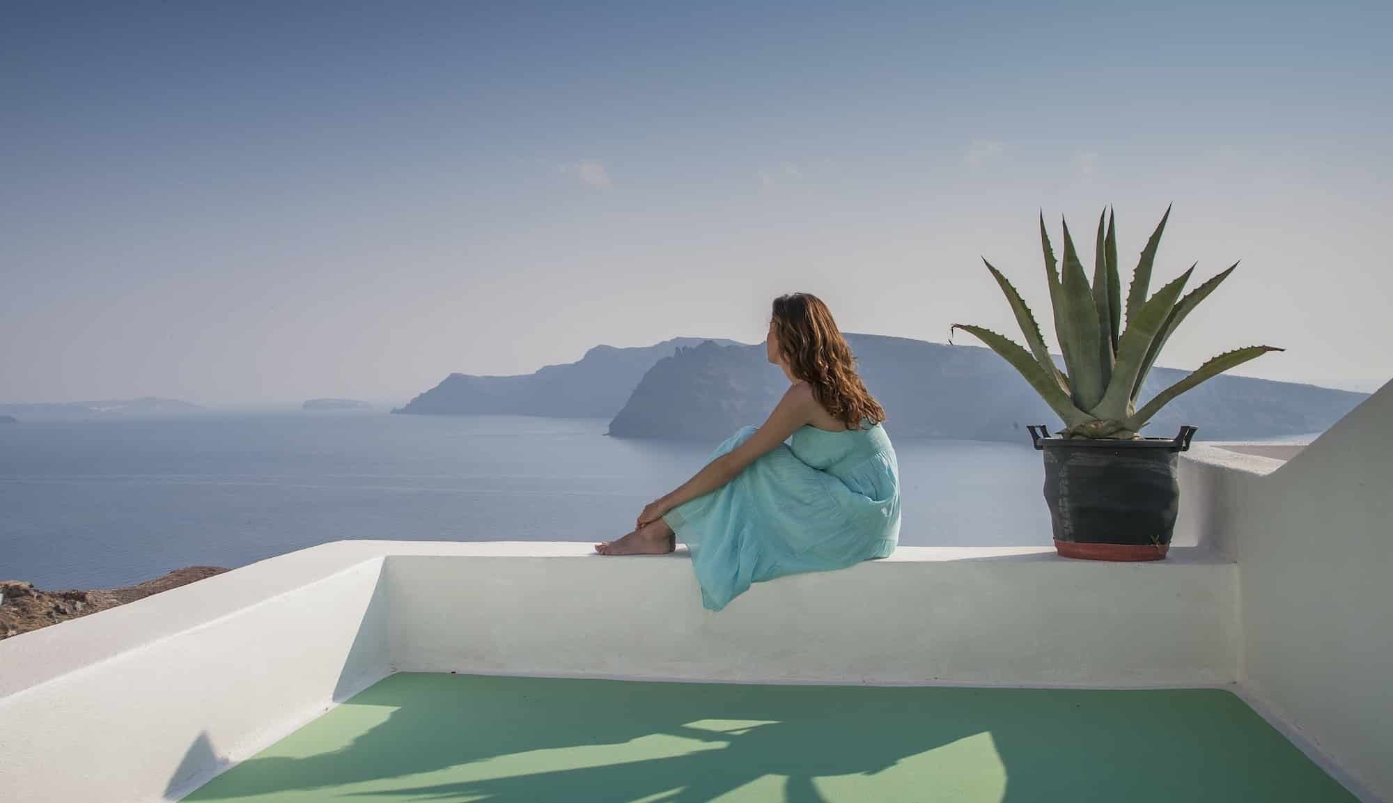 Woman on terrace looking away at view of sea, Santorini, Cyclades, Greece