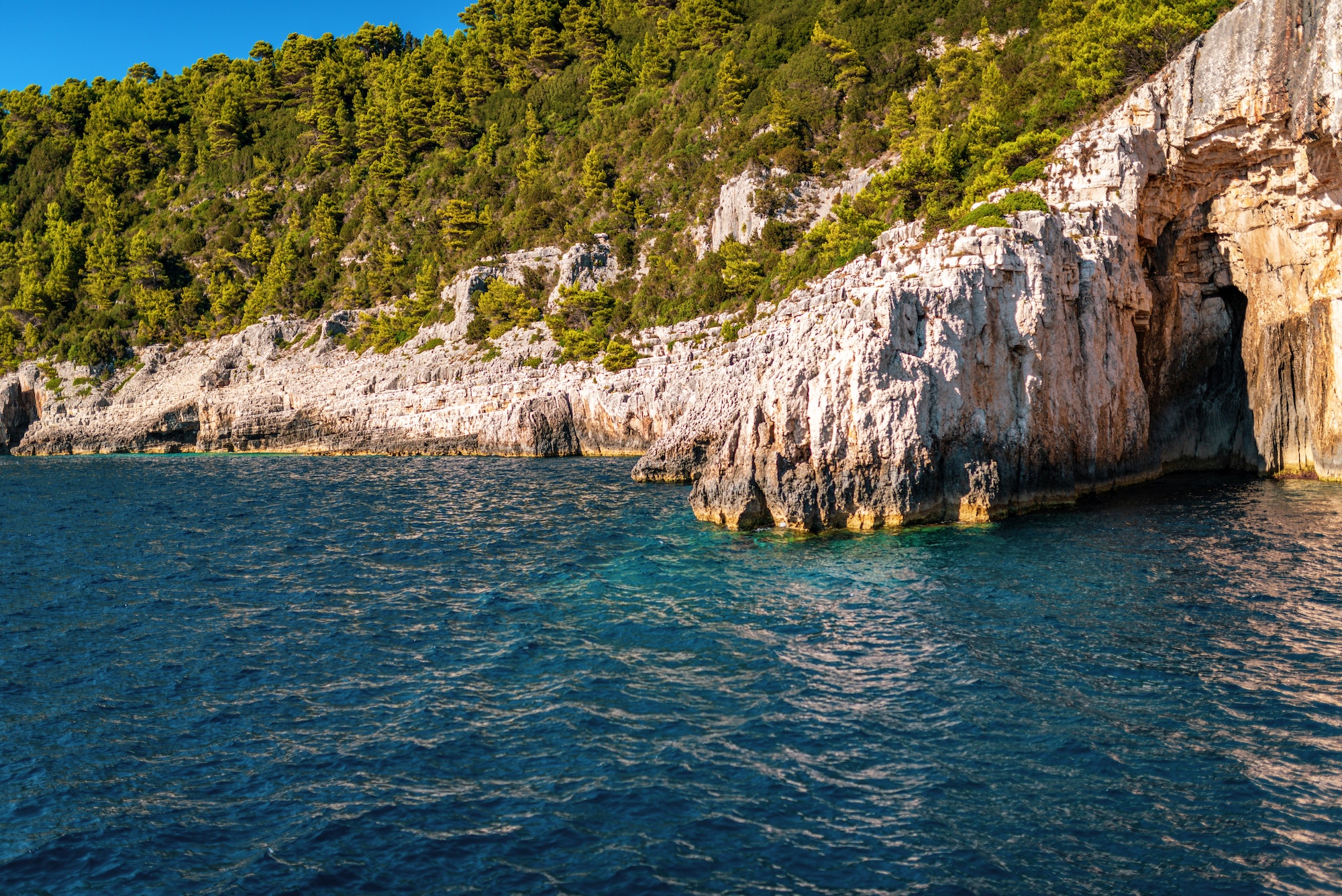 White-stoned rocks creating cave in Corfu island sea beach